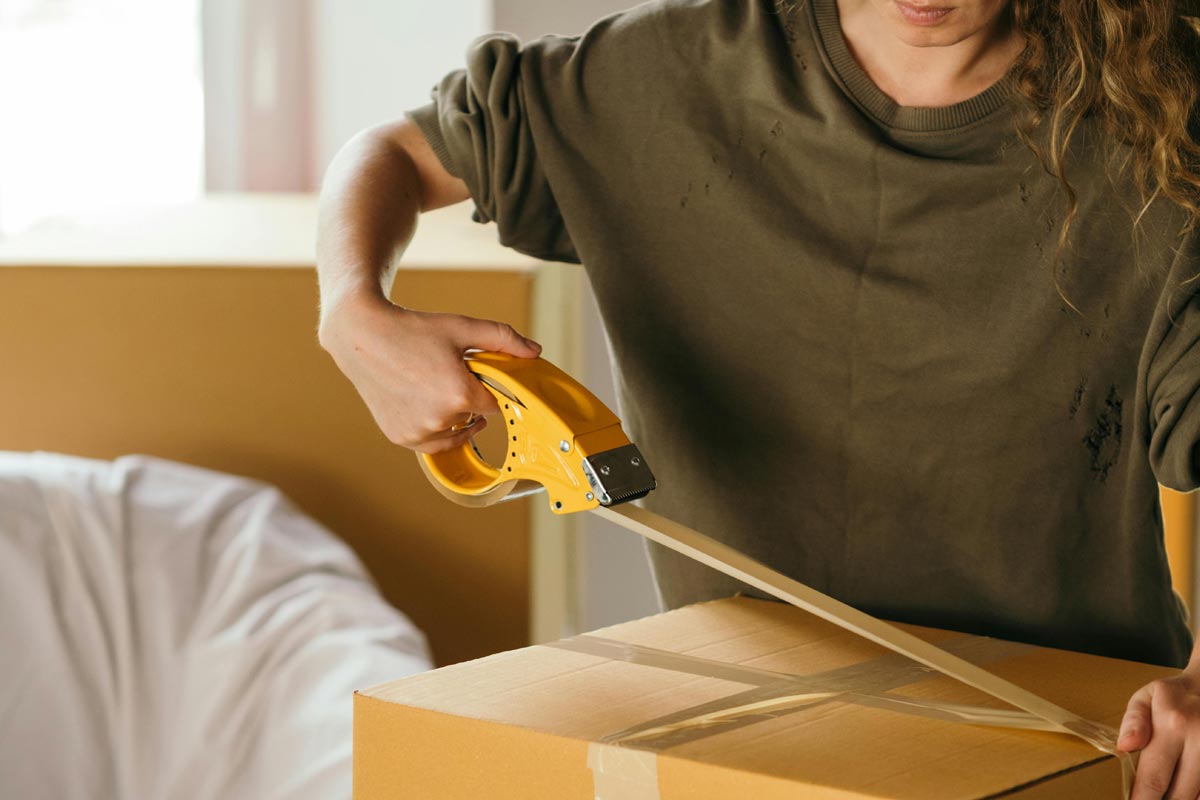 Lady Taping a box closed